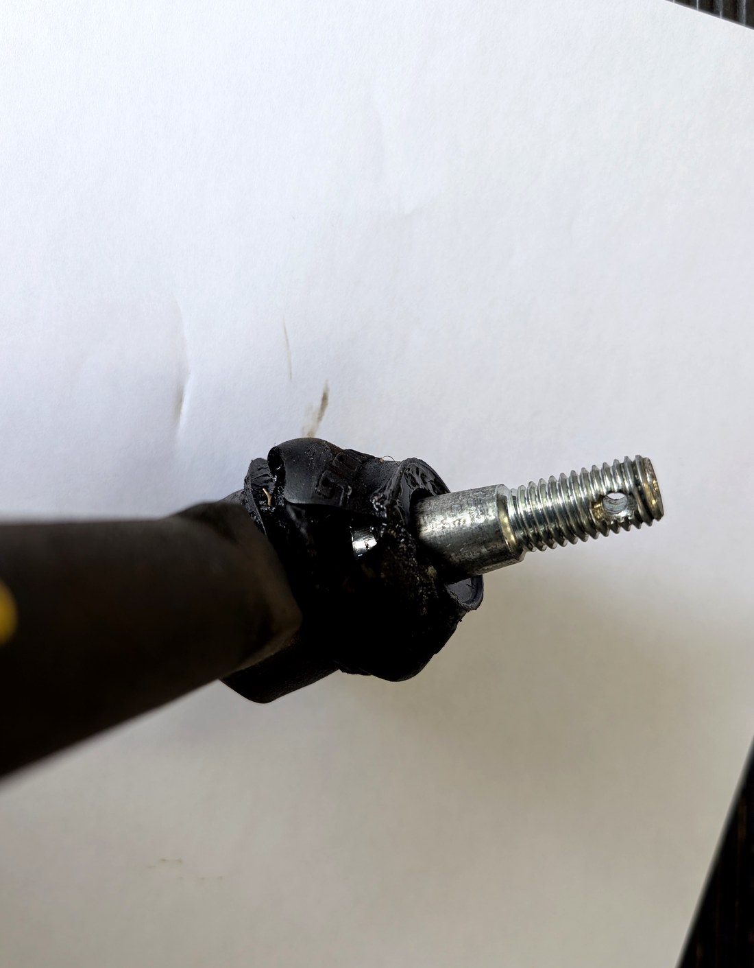 Close-up of failed rubber tie rod end boot on Moog tie rod