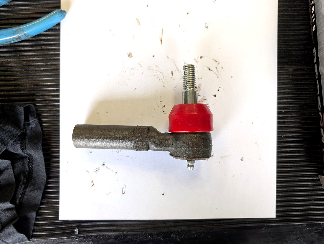 Moog tie rod end with Energy Suspension polyurethane boot installed on bench