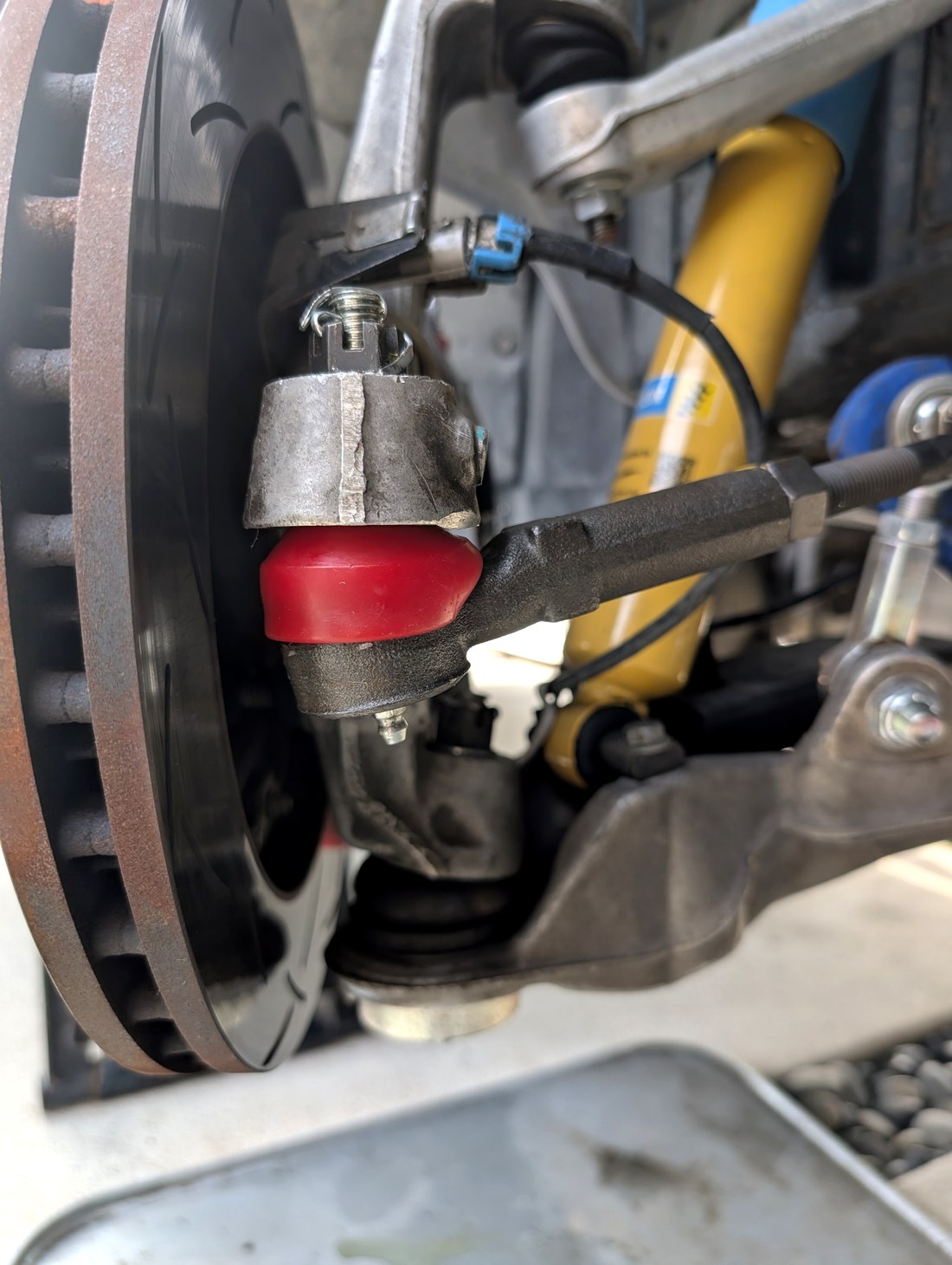 Energy Suspension red polyurethane tie rod end boot installed on C5 Corvette front suspension